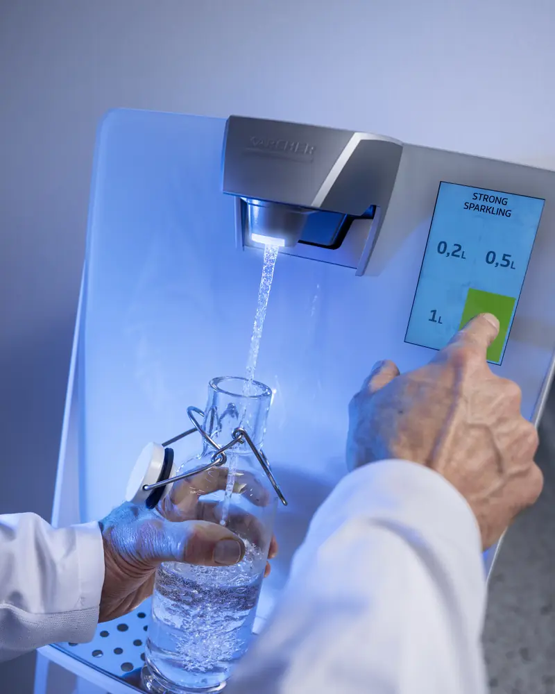 Glasflasche wird am Kärcher Wasserspender WPD 70 gefüllt, ohne den Auslass zu berühren