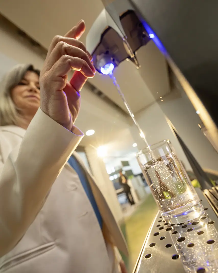 Karaffe wird am Kärcher Wasserspender gefüllt