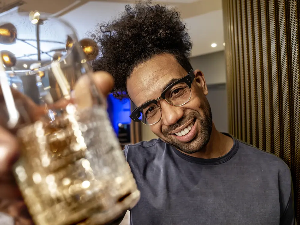 Gast trinkt ein Glas Wasser in einer Hotellounge mit schwarzem Kärcher Wasserspender